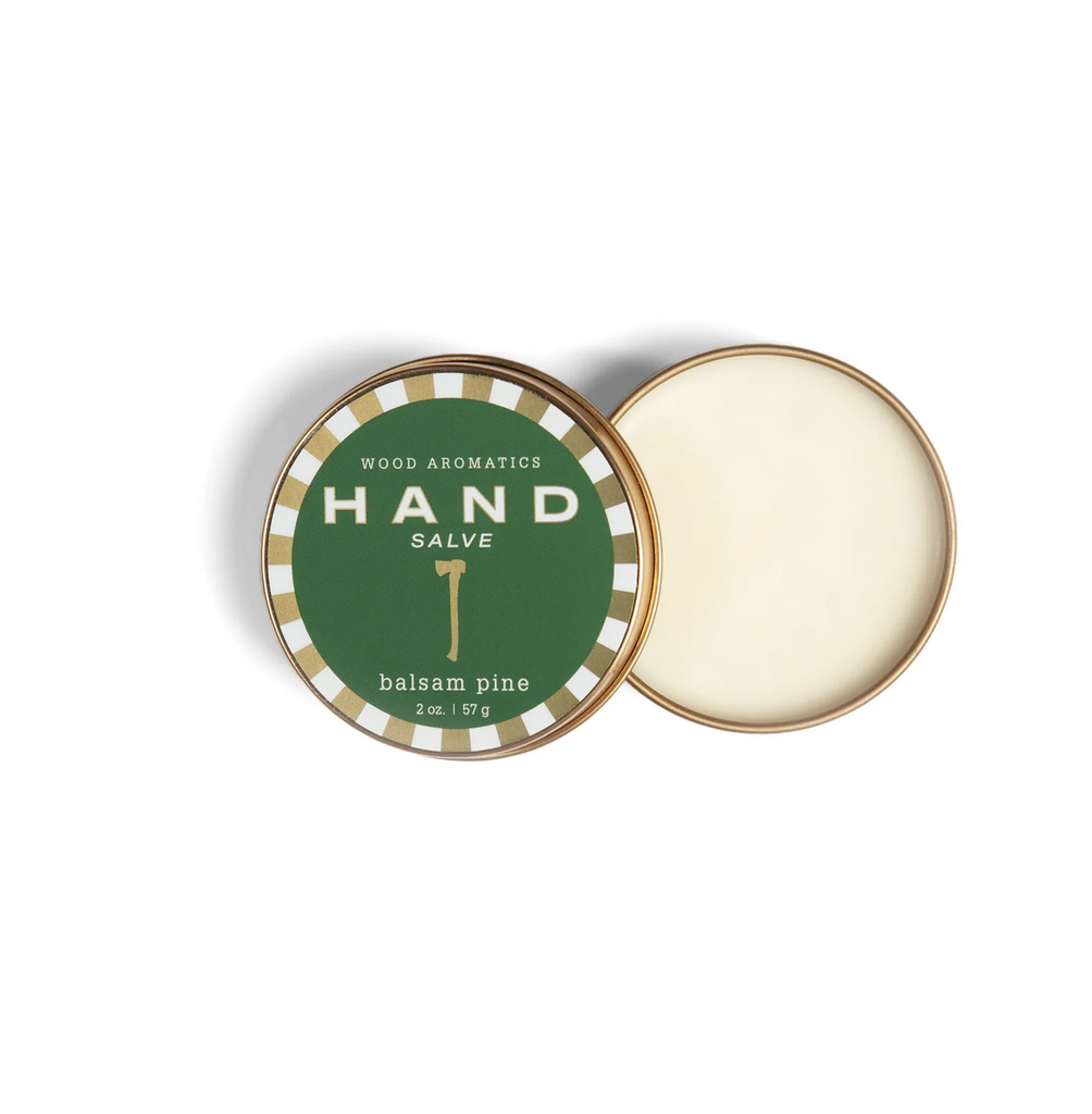 Hand Salve tin with image of a gold axe on a green background. Text reads: "Wood Aromatics Hand Salve Balsam Pine, 2 oz"