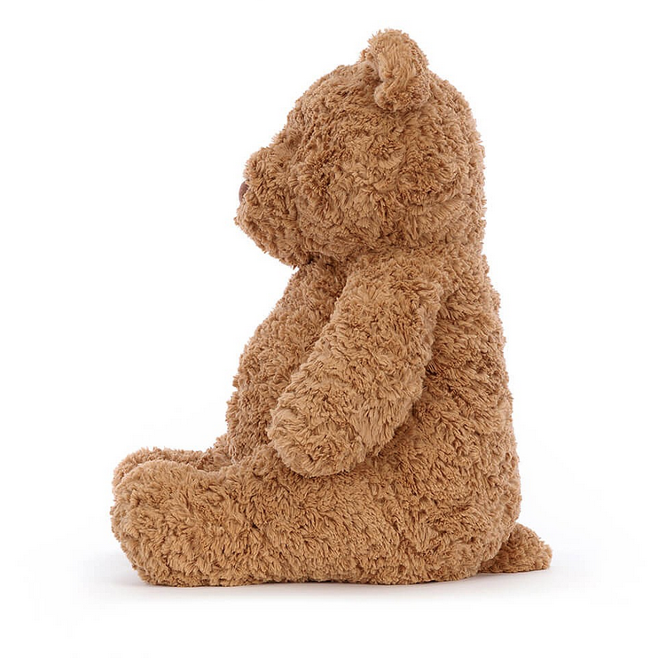 Side view of Bartholomew Bear plush. 