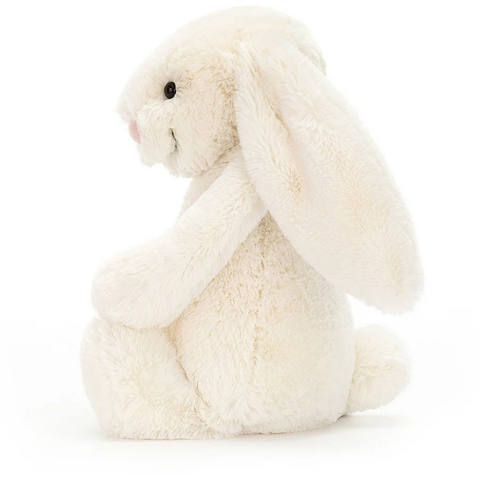 Side view of the Bashful Cream Bunny with long lop ears and white cottontail. 