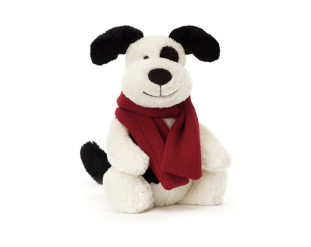 White dog with black spots plush wearing  a red scarf.