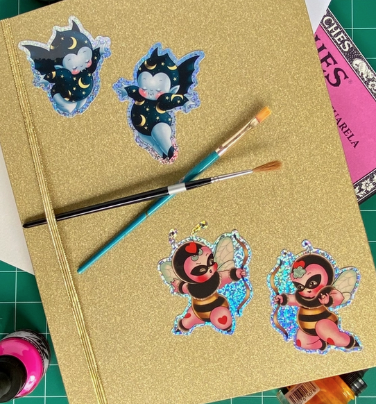 Vincent & Bella Bat and Mason & Melli Bee stickers applied to a gold glitter notebook. 