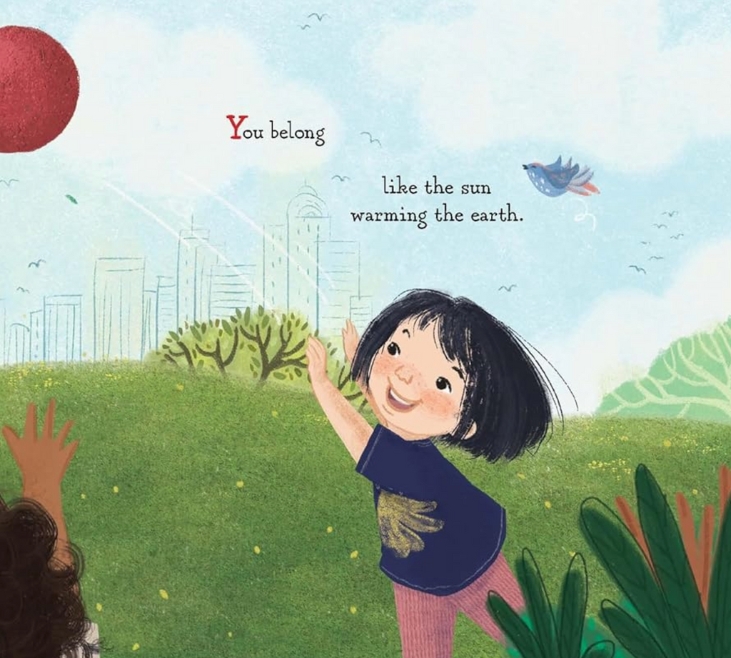 Interior page from "Belong" with an illustration of a young girl playing outside and an excerpt that reads "You belong, like the sun warming the earth." 