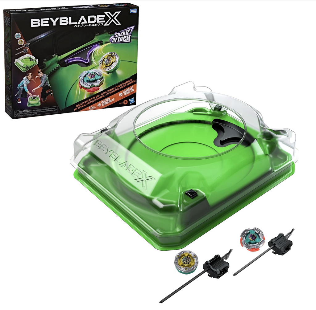 The Beyblade X Sneak Attack Beystadium, 2 Infinity tops, and 2 launchers set up in front of the box they are packaged in with images of the tops battling for the high score. 