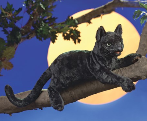Plush Black Cat puppet posed in a branch of a tree with a full moon in the background. 