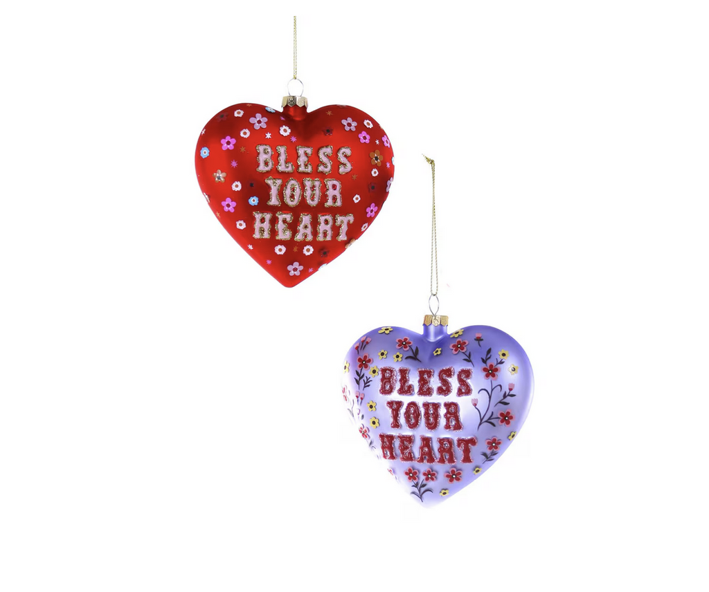 Heart shaped glass ornament in either red or light purple that says Bless Your Heart in red text surrounded by flowers.