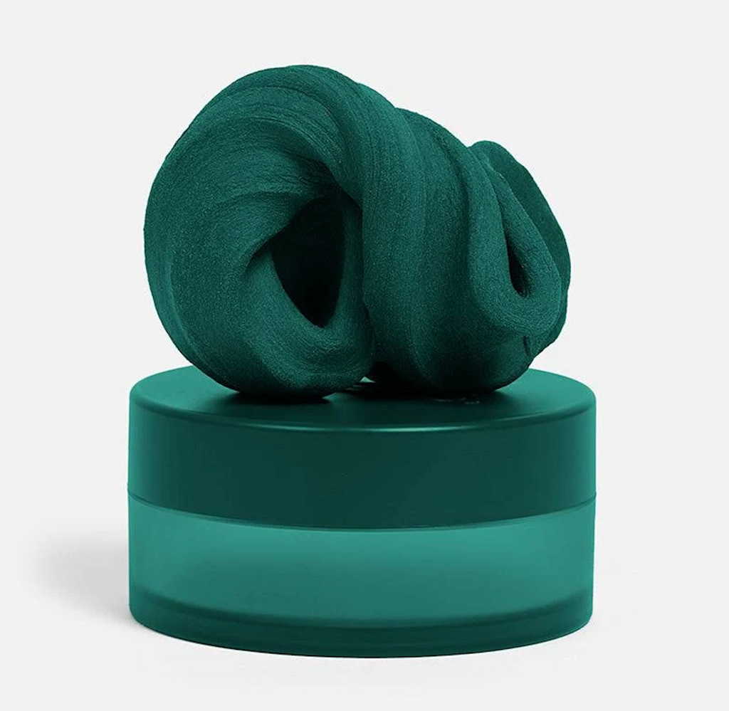 A frosted green container with dark green top with some of the Forest putty piled on top. 