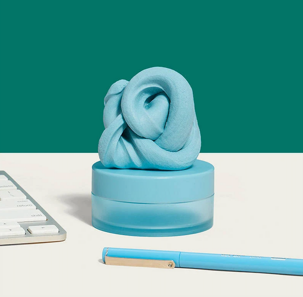 Blur Focus Putty a light blue putty resting on top of the matching container it comes packaged in. 