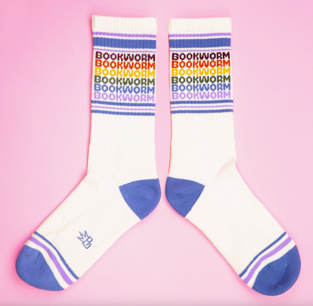 White tube socks with light blue and purple stripes with "Bookworm" repeated in rainbow colors. 