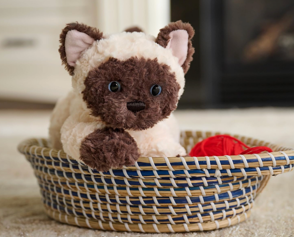 Bootsie the Siamese Kitten plush toy in a basket. 