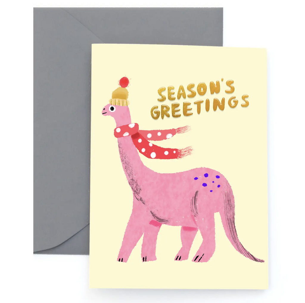 Holiday greeting card with an illustration of a pink dinosaur wearing a scarf and hat. The card reads "Season's Greetongs" in gold lettering. 