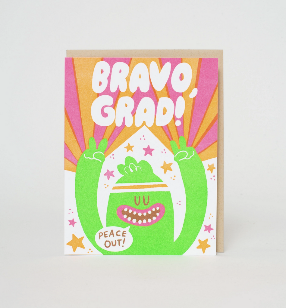 Greeting card with a colorful illustration of a green monster with it's arms up in the air and a word bubble that reads "Peace Out!" and white lettering above it's head that reads "Bravo Grad" 