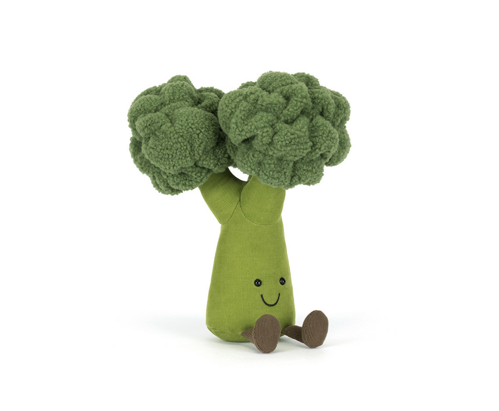 Plush green broccoli with a smiling face sitting on a white background.