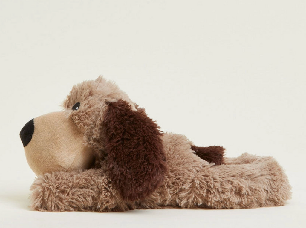 A plush stuffed dog toy stretched out on it's tummy.  The weighted plush brown dog has a light beige face and paws, a medium brown body, and a darker brown floppy ear.