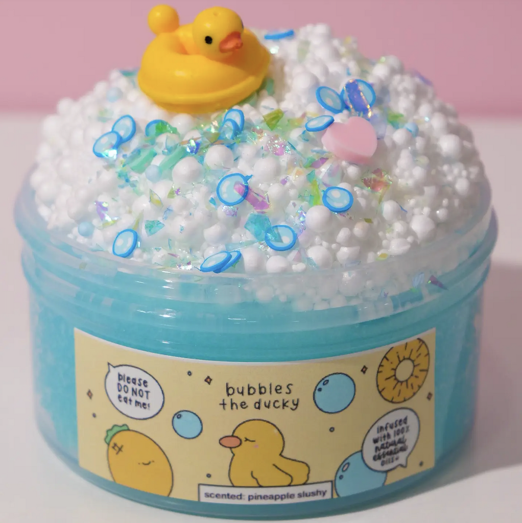 Bubbles the Ducky blue slime in a tub with white floam, a yellow ducky and bubble shaped confetti on top. (Not food)