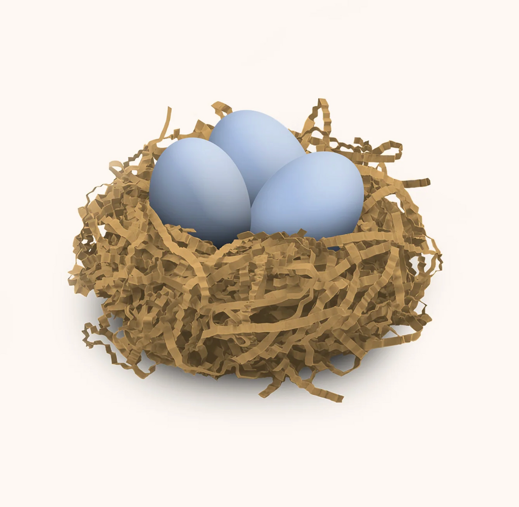 Three blue egg shaped bath bombs nestled in a paper nest. 