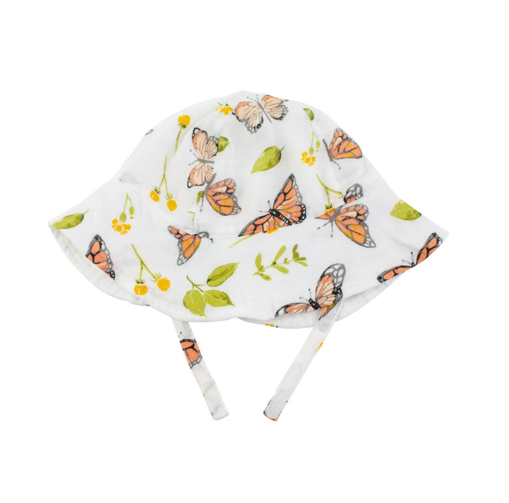 Wide brimmed sun hat with chin strap. Muslin fabric has white background with orange monarch butterflies and light green leaves and yellow flowers. 