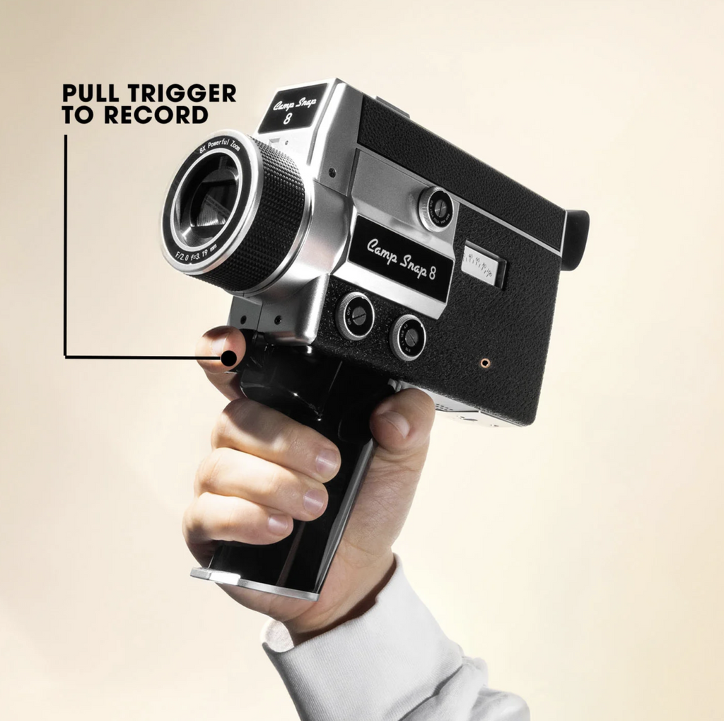 Hand holding the CS-* digital video camera on a tan background