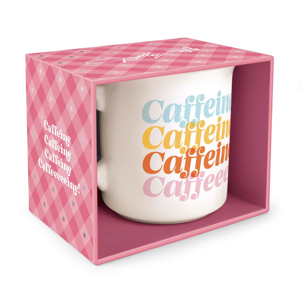 White ceramic mug packaged in a pink gingham box with foil rhinestone accents. The mug has "caffeine" in a repeating pattern and different colored letters on each line. 