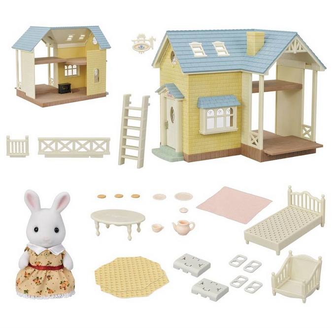 This cute cottage features two floors under a pale blue roof. It comes with Maisie Snow Rabbit with removable clothing, an armchair and table set with teapot, teacup, and plate with cookies, and a bed with pink blanket.