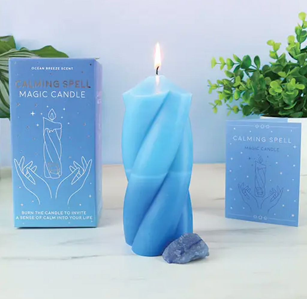 The Calming Spell Magic Candle with a two tone blue candle, blue crystal and the spell booklet that comes with it. 