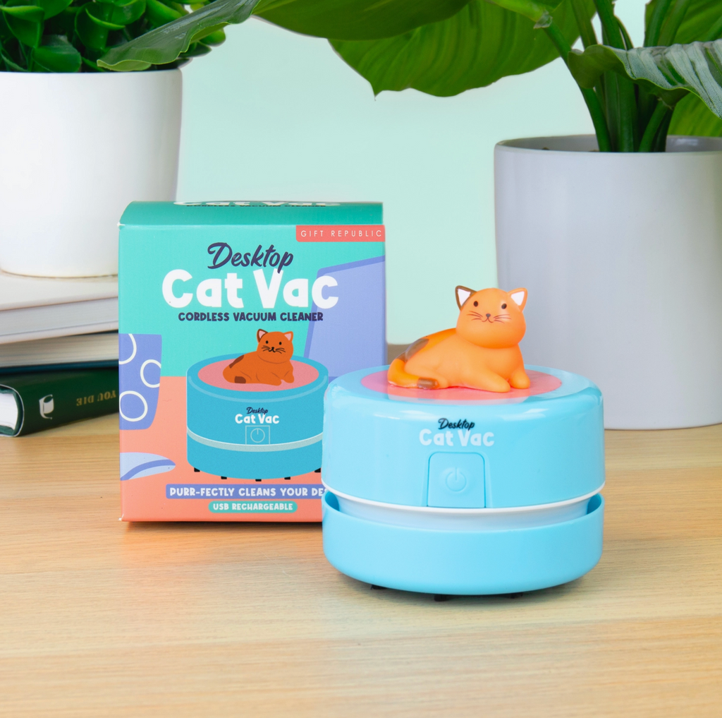 Blue Desktop Cat Vac with orange cat figure on a wooden surface next to its packaging.