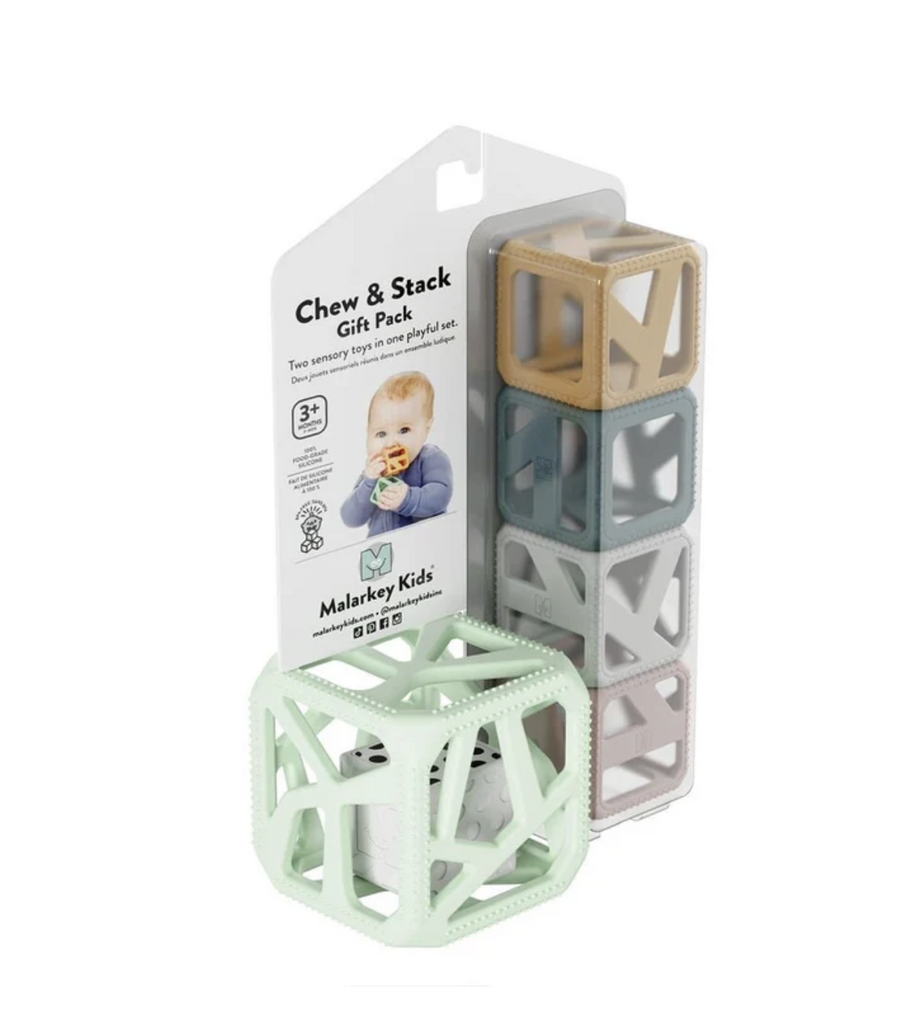 A mint green silicone cube with a white dice inside that rattles, packaged with four smaller cubes that are mustard yellow, slate blue, grey and dusky pink in color. All the cubes have geometric shaped holes that make it easy for baby to grasp and hold the cubes. 