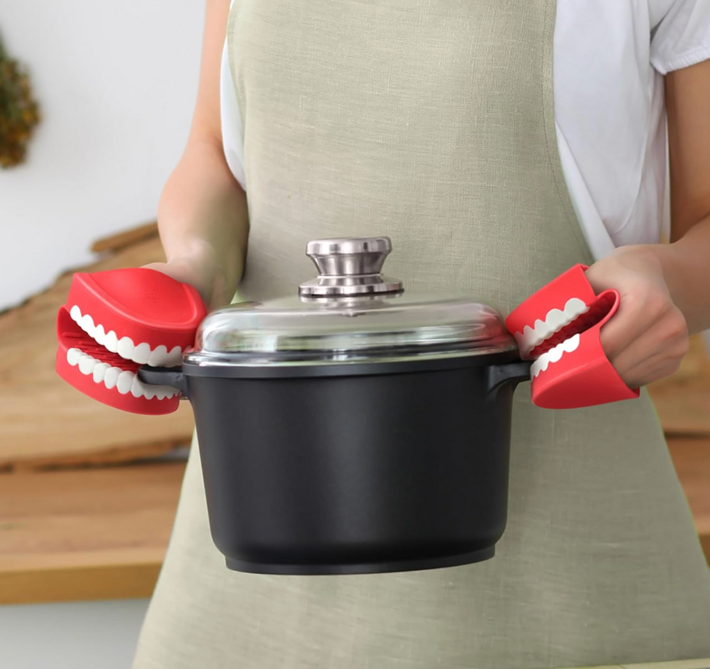 The Chomp pot holders being used to hold a dutch oven pot. 