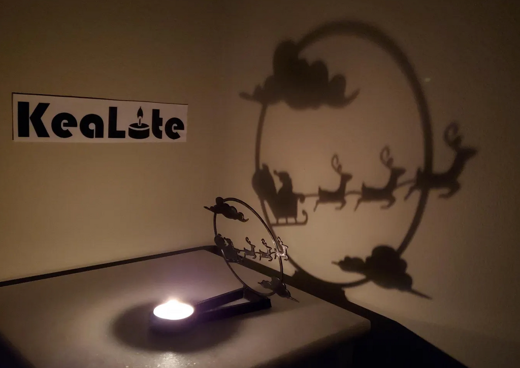 The Christmas Night Kealite Shadow Caster projected on a wall by a tea light. 