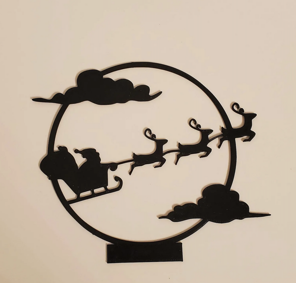 Christmas Night Shadow Caster with a silhouette of Santa driving his sleigh with reindeer. 