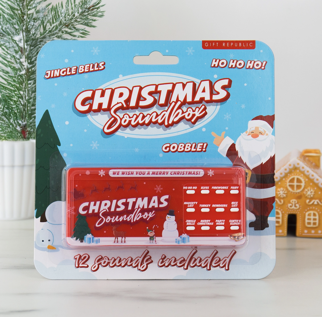The Christmas Soundbox packaged on a hang card with an illustrated winter scene featuring Santa, a snowman and pine tree. 