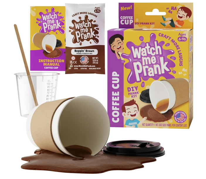 Prank coffee cup spill, with bright yellow box packaging in the background. The powder and mixing cup along with the instruction booklet are also featured. 
