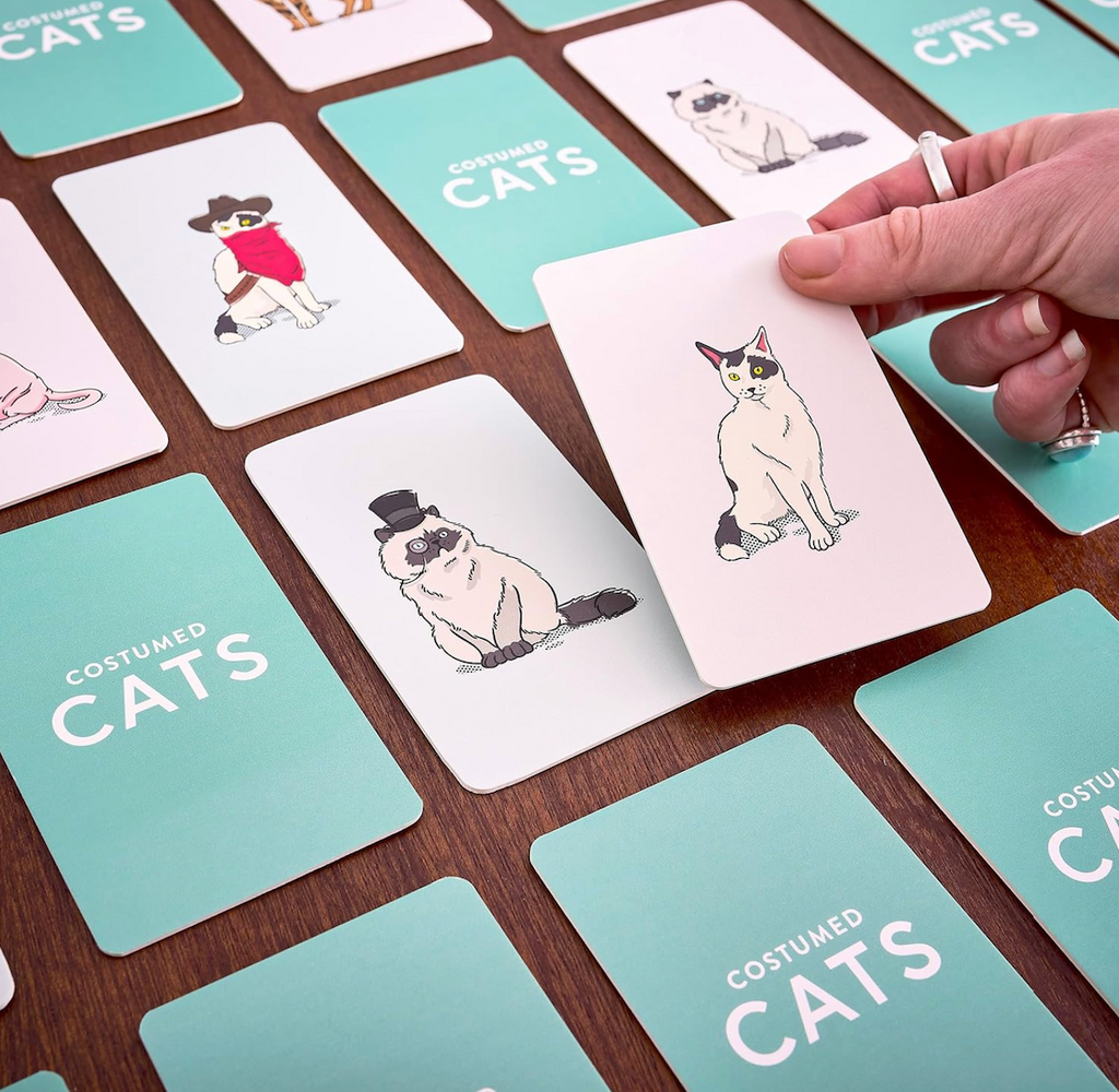 Costume Cats Memory Game set up for play with various cards with costumed cats flipped up looking to be matched. 