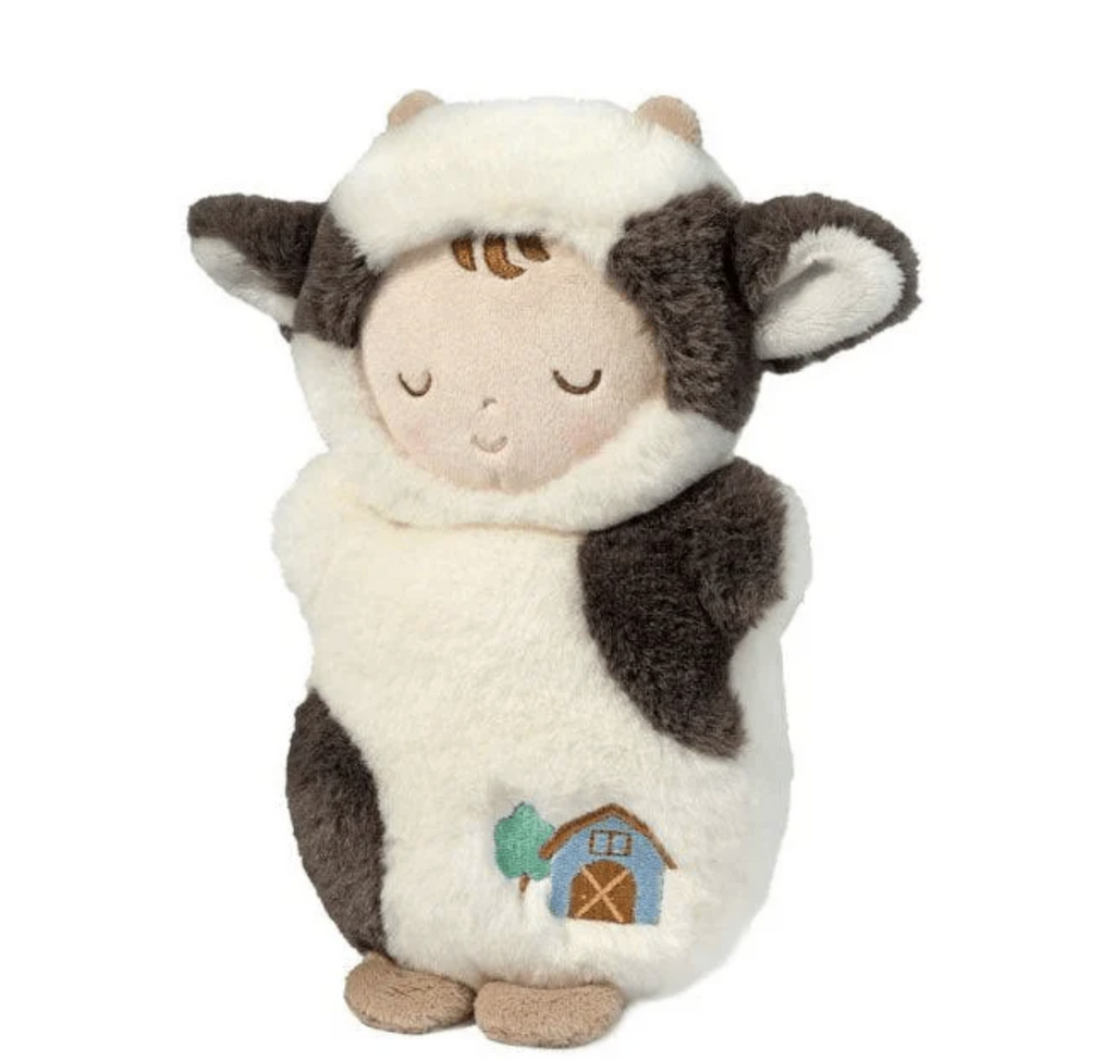 Sweet plush baby doll wearing a baby cow costume complete with a hood that has fuzzy ears and horns. 