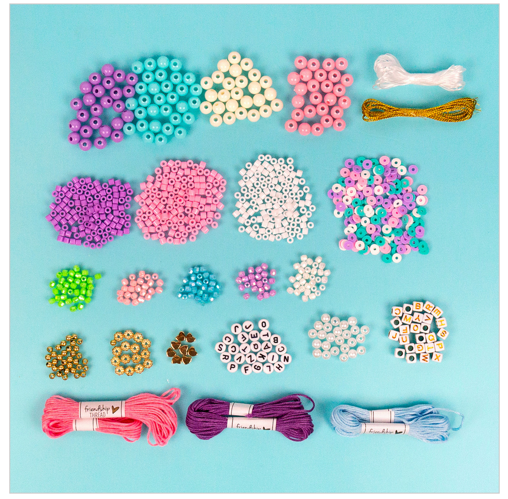 Piles of included colorful beads, charms, letters, and bracelet thread on a light blue background.