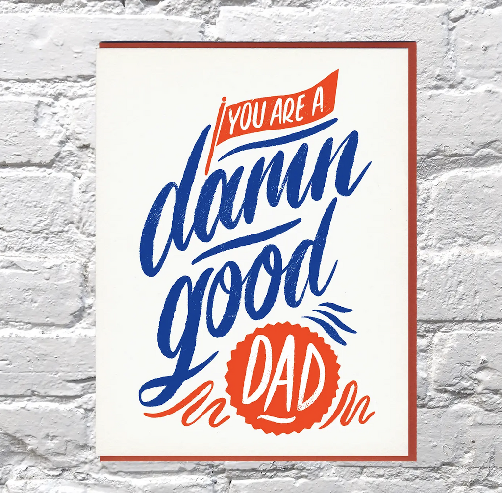 White greeting card with the message "You are a damn good Dad" in blue and red lettering. 