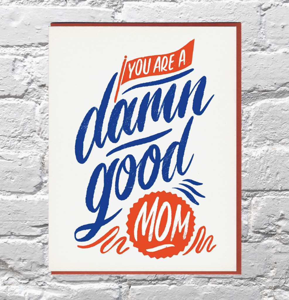 Mother's Day card that reads "You Are A Damn Good Mom" in red, white and blue lettering, 