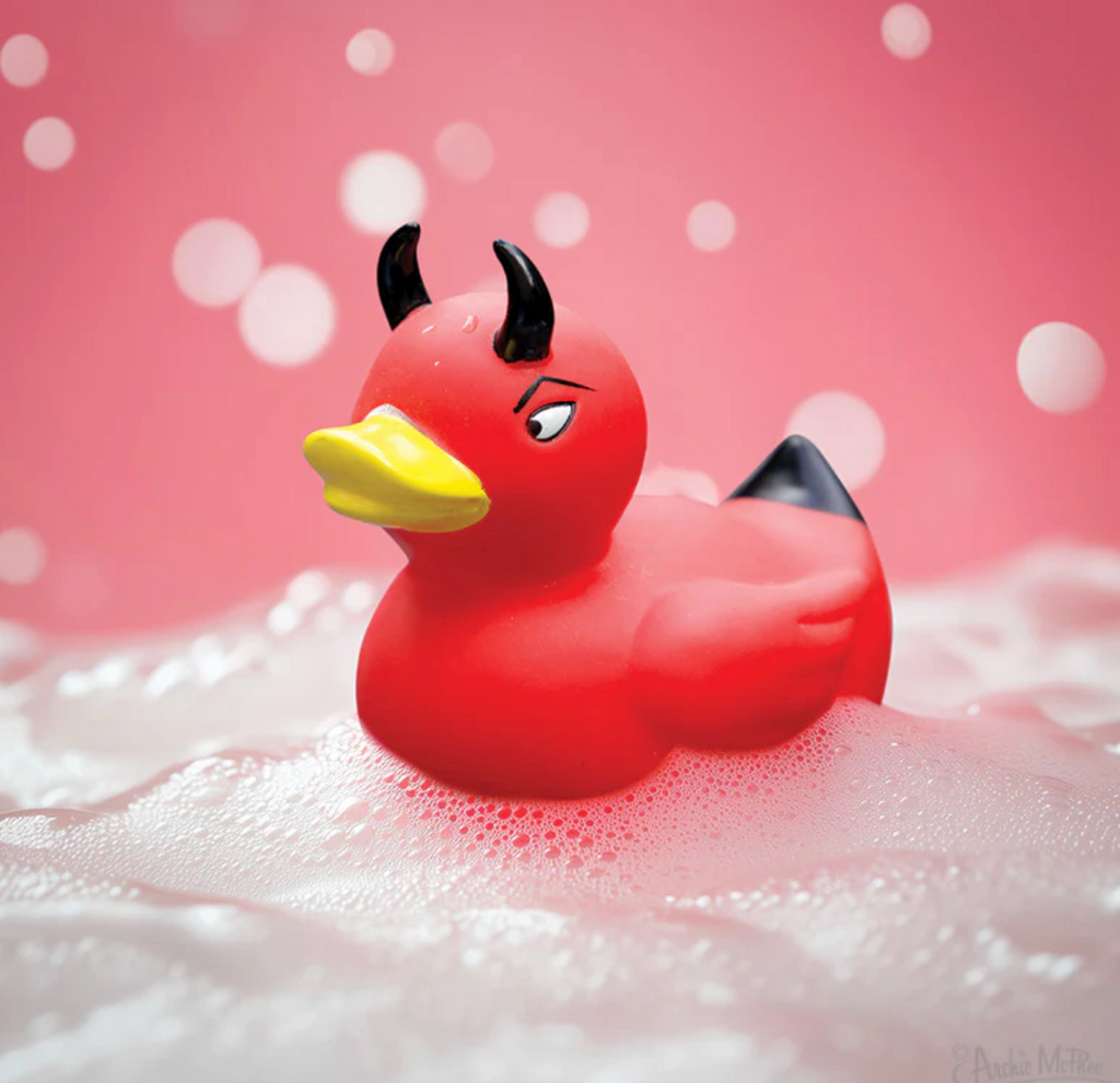 Red devil duck rubber duck floating on soapy foam.