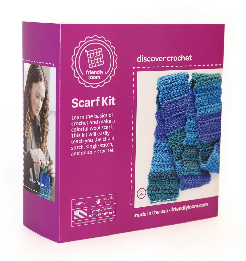 Purple and white box with a picture of a completed crocheted scarf in blue and green colored yarns that are included in the Discover Crochet Scarf Kit. 
