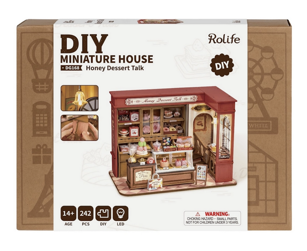 Craft box with a color picture of the Honey Dessert Talk DIY Miniature House assembled with the accessories set up like a patisserie shop. 