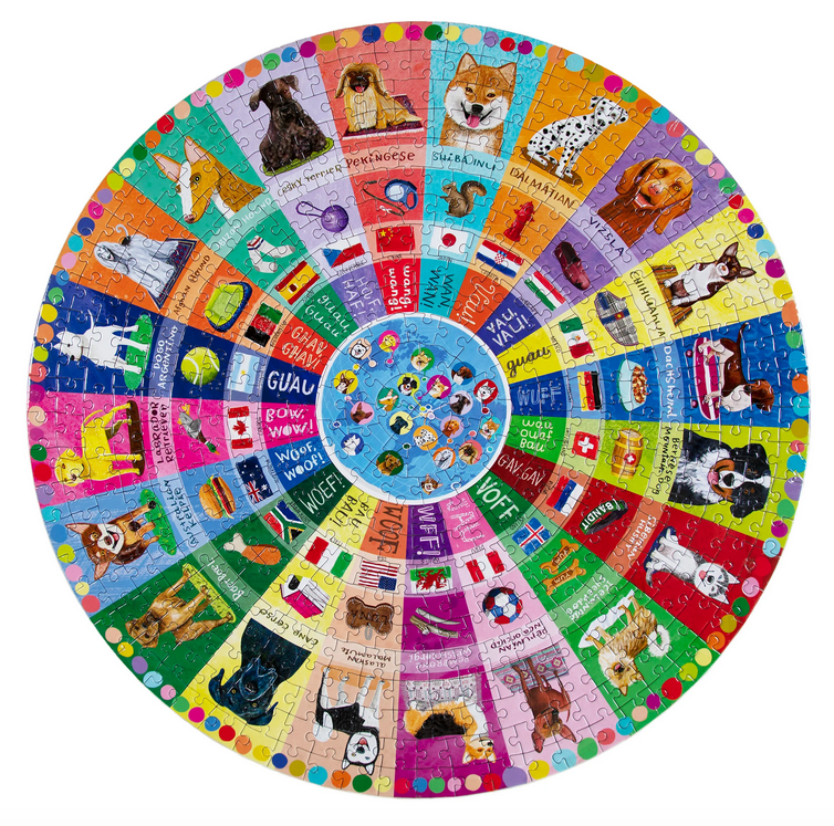 Completed Dogs of the World round jigsaw puzzle. Each breed has its own color sliver that provides the name of the breed, the flag of its native country, how you say “woof” or “ guau” in that country’s language. Plus, a ring that shows all the things canines like to play with, use, or chase…. A slipper, a ball, a squirrel, and lots more.