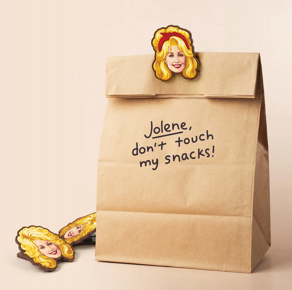 Dolly Parton bag clip attached to a brown paper bag that has "Jolene, don't touch my snacks" written on the front. 