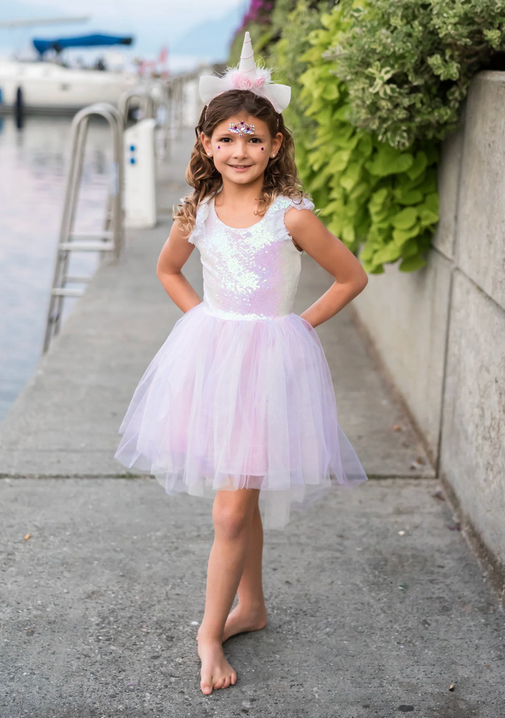 Picture of a young lady wearing the Dreamy Unicorn Dress and headband. 