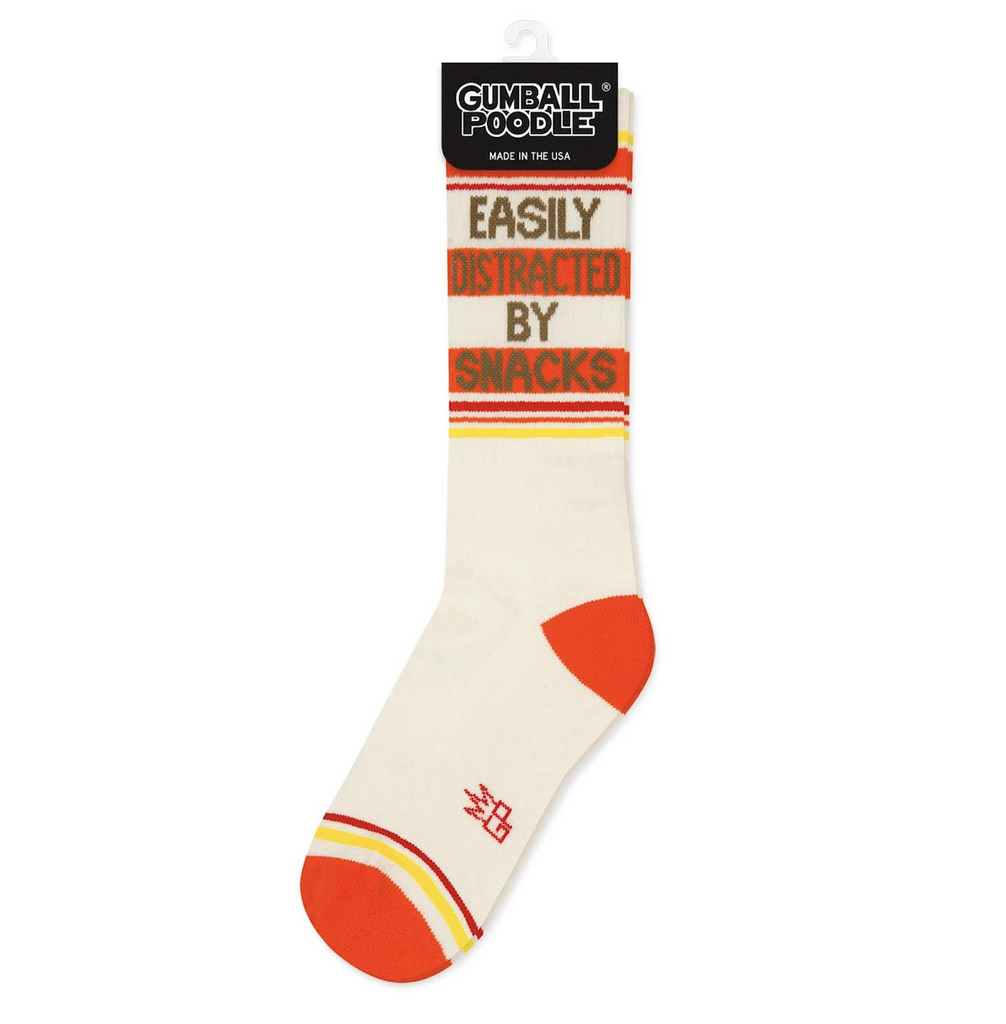 White tube socks with orange, red and yellow stripes and brown lettering that reads "Easily Distracted By Snacks" 