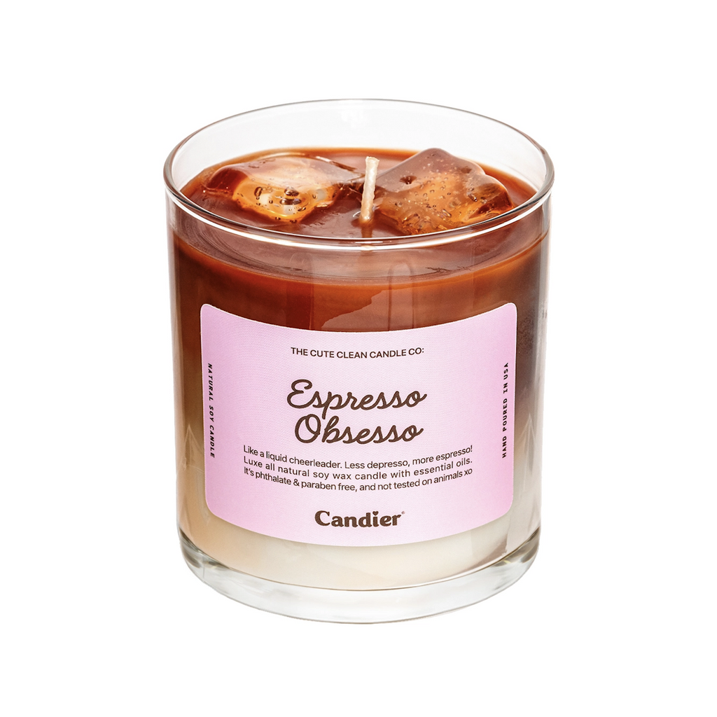 Jar candle with two toned colored wax that makes it look like a glass of iced espresso with ice cubes floating on the top. A pink label has the words Espresso Obsesso and a description of the scented candle. 