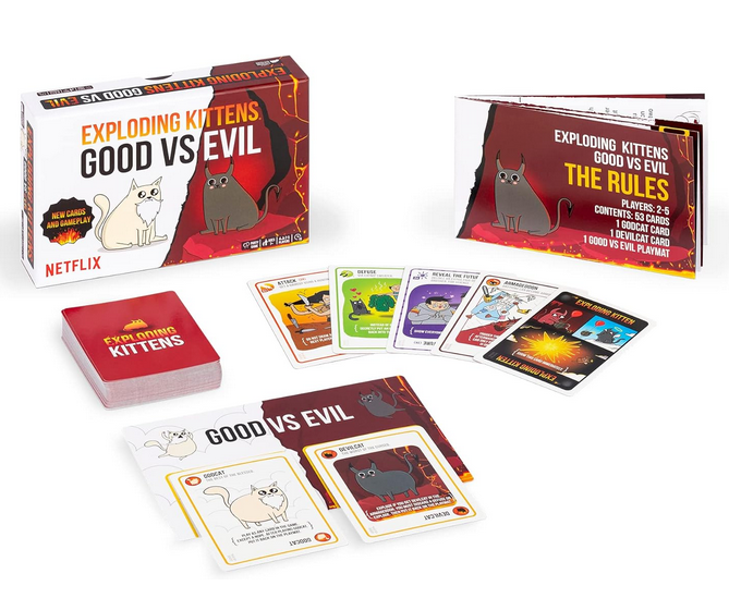 Exploding Kittens Good vs Evil game set up and in play with some action cards face up and the rule book on the side. 