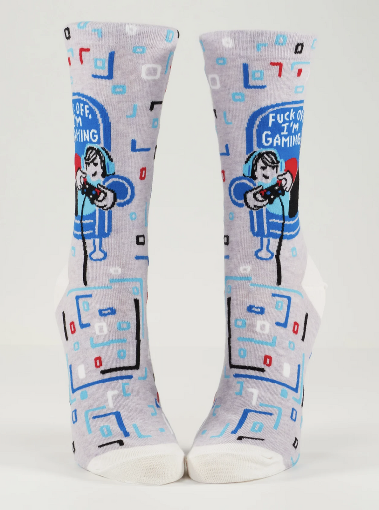 A pair of socks on mannequin feet that read "Fuck Off I'm Gaming" with blue and grey illustrations of a gamer. 