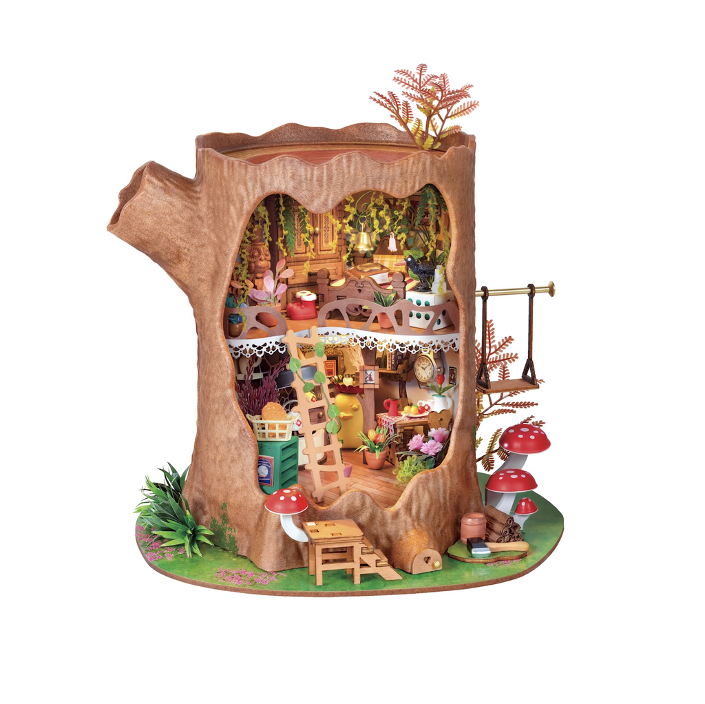 Close up view of the Fairytale Tree House DIY Miniature House, an old two story tree stump filled with whimsical details, plants, and tiny décor. 