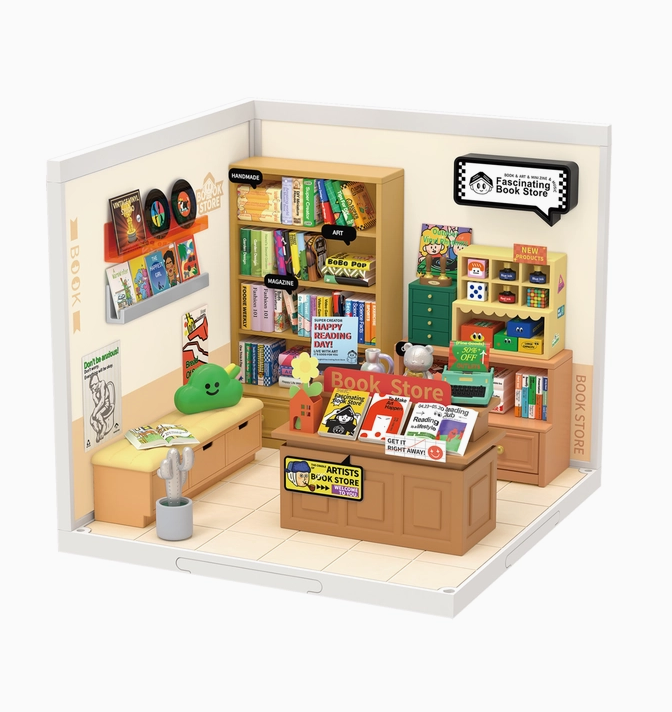 Close up of the completed model with bookshelves and tables full of books, a play area with toys and a couch for reading. 