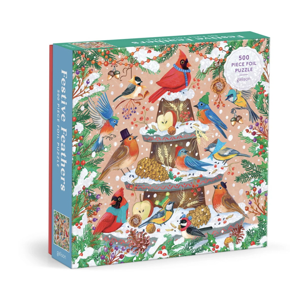 Illustrated Festive feathers 500 piece foil puzzle features different winter birds with scarves and hats on a snowy stand with apples and birdseed.