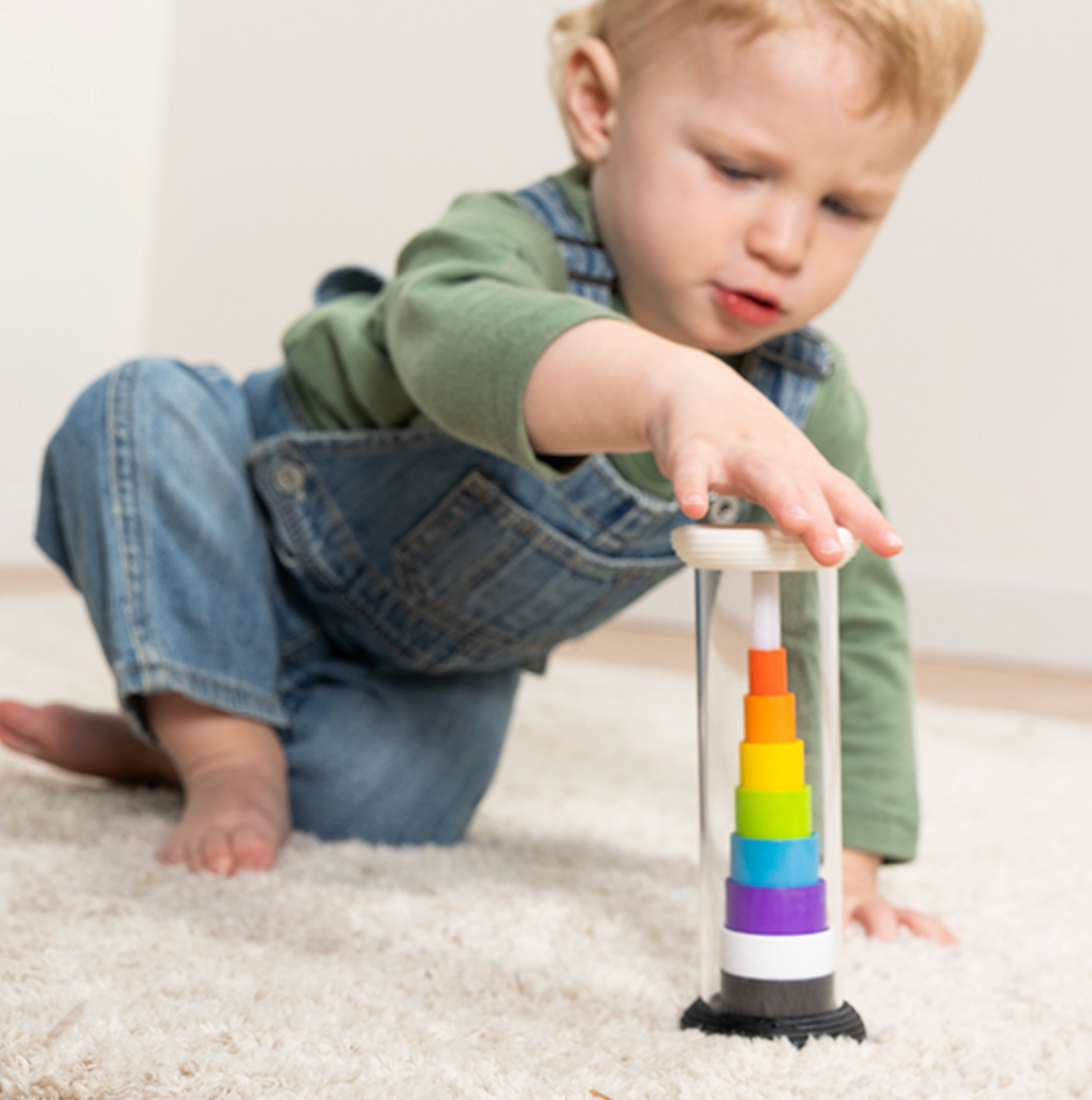 A child playing with Flipty with the rings in ascending sizes with the rainbow colors revealed. 